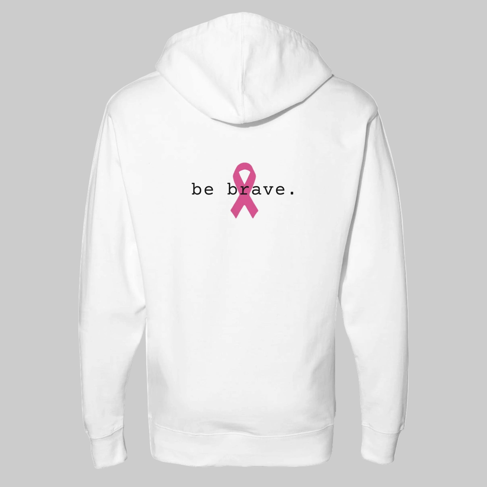 A white pullover hoodie is shown from the back, featuring the word 'be brave.' in white text and a pink awareness ribbon graphic in the center.