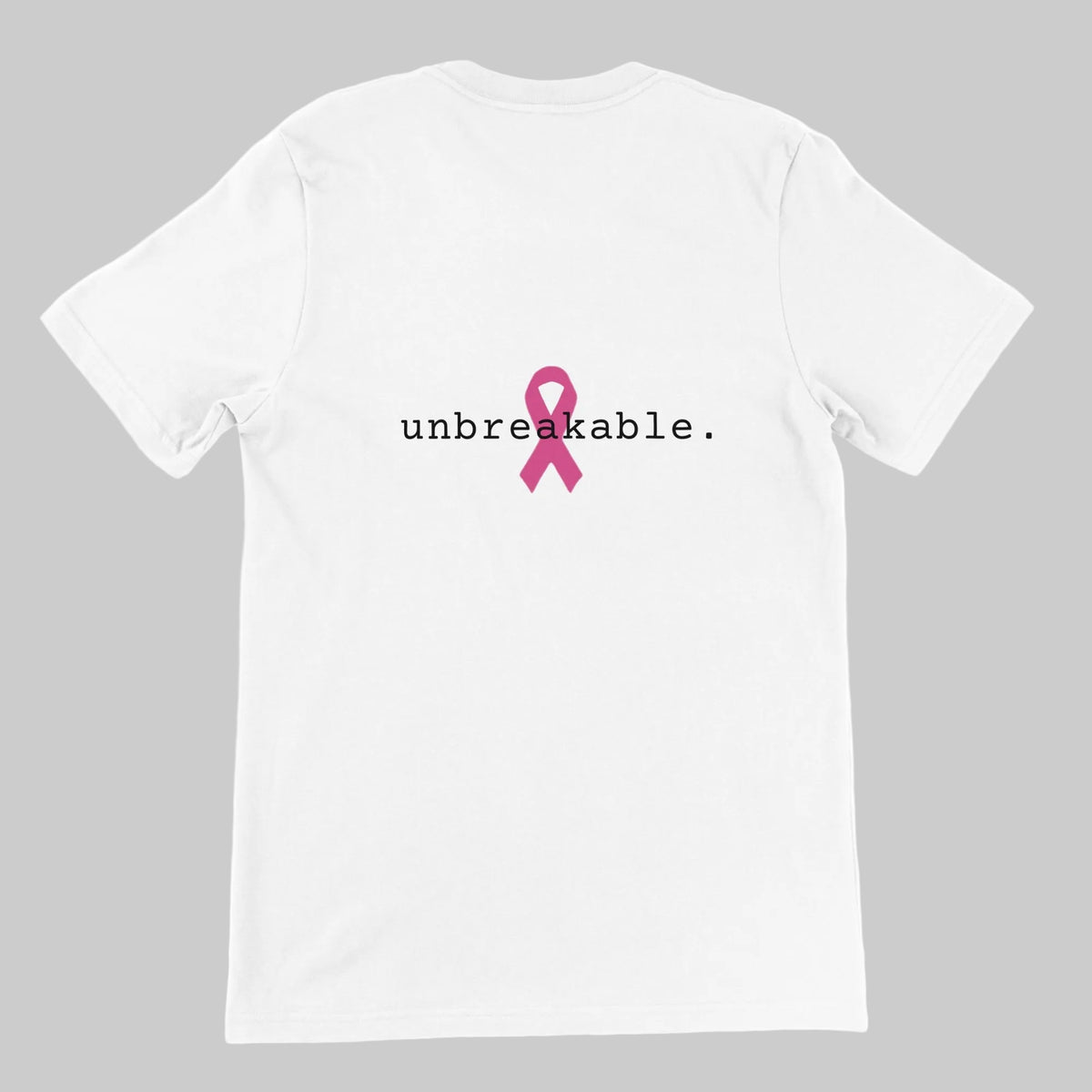 A white short-sleeve t-shirt shown from the back, featuring the word 'unbreakable.' in black lowercase text with a pink awareness ribbon graphic in the center on a warm grey background